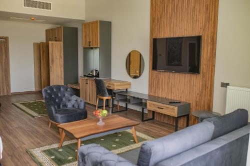 a living room with a couch and a desk and a television at The Green Oasis Otel Spa in Kadıköy