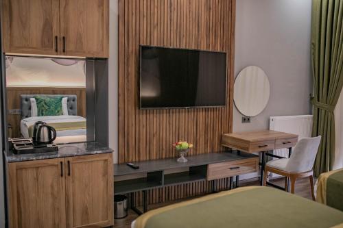 a hotel room with a bed and a desk with a television at The Green Oasis Otel Spa in Kadıköy