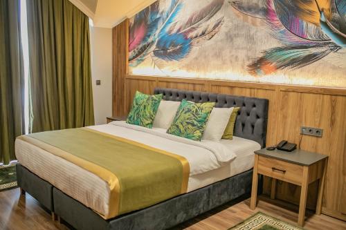 a bedroom with a bed with a painting on the wall at The Green Oasis Otel Spa in Kadıköy
