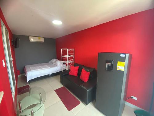 um quarto com uma parede vermelha e um beliche em La casita de max y tim apartaestudio 4to piso em Cartagena das Índias