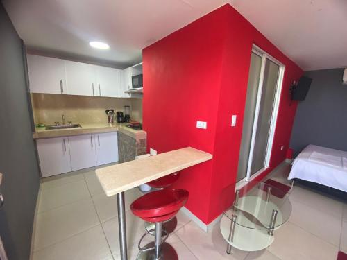 una pequeña cocina con paredes rojas y una pared roja en La casita de max y tim apartaestudio 4to piso en Cartagena de Indias