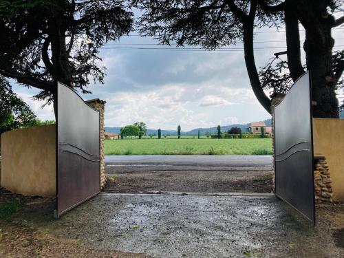 a pair of metal gates leading to a road at Gite Harmonie in Gréoux-les-Bains