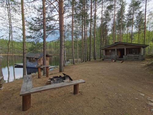 a cabin in the woods next to a lake at Pattoinlampi Saunamökki 
