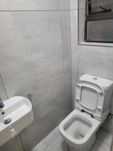 a bathroom with a toilet and a sink at MIRAJO Guest House in Cape Town