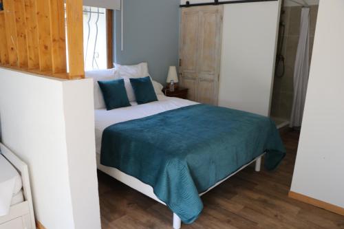 a bedroom with a bed with a blue blanket on it at Le Mas des Cerisiers JACUZZI et SAUNA inclus pour tous les logements in Avignon