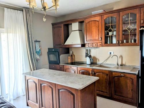 a kitchen with wooden cabinets and a sink and a stove at Serene Sea View Apartments in Utjeha in Utjeha