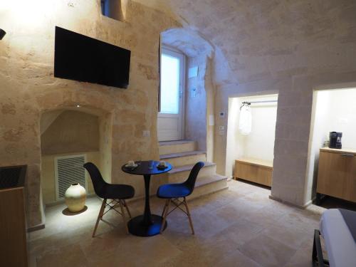 a living room with a table and chairs and a fireplace at Dimore dei Mercanti in Matera