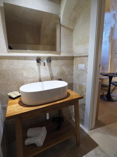 a white sink on a wooden table in a bathroom at Dimore dei Mercanti in Matera