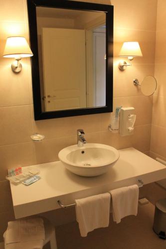 a bathroom with a sink and a mirror and towels at Il Parco Sul Mare Resort & SPA in Tortoreto Lido