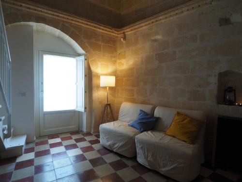 a living room with a white couch and a window at Dimore dei Mercanti in Matera
