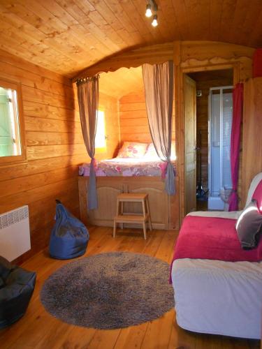 1 dormitorio con 1 cama en una cabaña de madera en Roulotte du Mas Rondole en Saillagouse