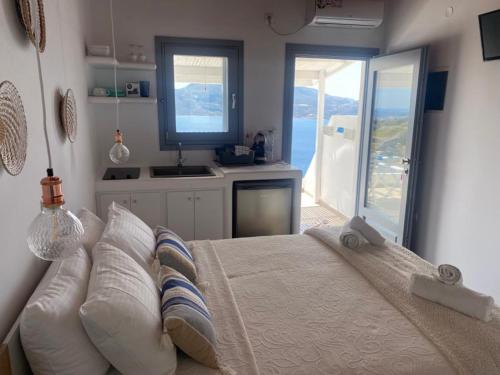 a bedroom with a bed with a view of the ocean at Studios Betty in Plaka Milou