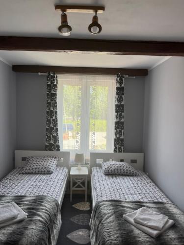 two beds in a room with a window at Słoneczny Wodnik in Braniewo