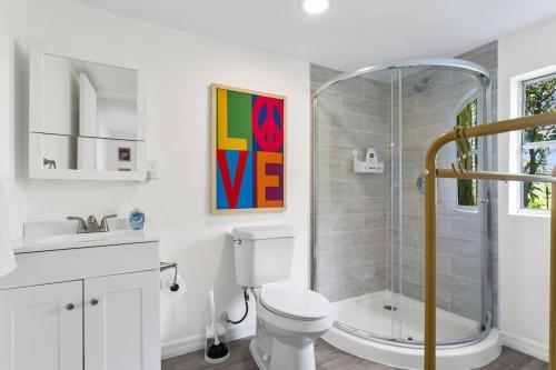 a bathroom with a shower and a toilet and a sink at That 70’s Themed Apt Close to Coffee, Food + Shops in Tampa