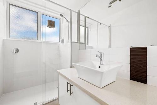un bagno bianco con lavandino e doccia di South Yarra apartment with stunning views a Melbourne