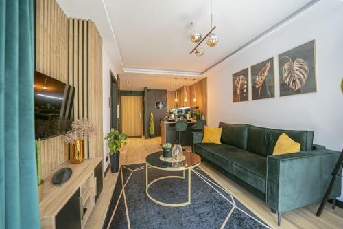 Apartament Black Diamond في شكلارسكا بوريبا: غرفة معيشة مع أريكة خضراء وطاولة