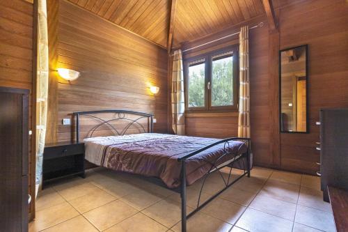 1 dormitorio con 1 cama en una habitación con paredes de madera en Petite Maison En Bois Exotique en Figari