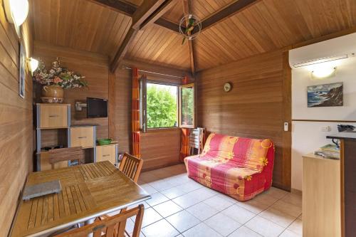 a living room with a couch and a table at Petite Maison En Bois Exotique in Figari