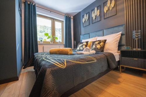 a bedroom with a bed with a blue wall at Apartament Black Diamond in Szklarska Poręba