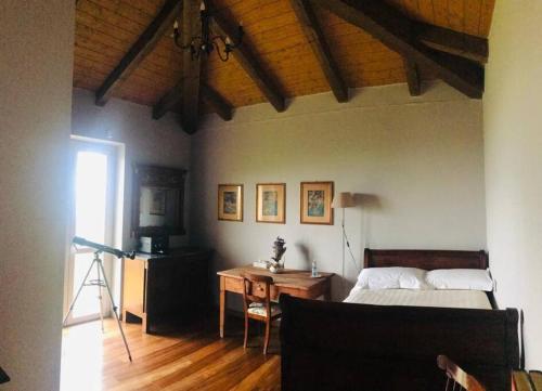 um quarto com uma cama, uma secretária e uma mesa em Country house in the Langhe with vineyard em Dogliani
