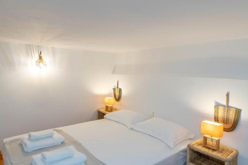 a bedroom with a white bed with two lamps and towels at Chora 5 - Central Rooms by TinosHost in Tinos Town
