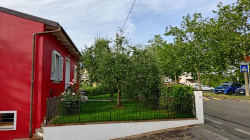 a red house with a fence and a tree at Tuscan Orchard in Montespertoli