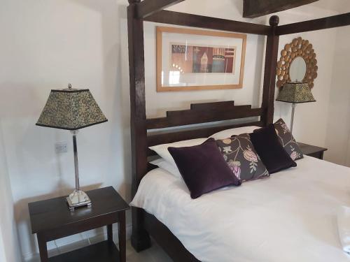 a bedroom with a bed and two lamps and a mirror at Granary Villa in Kidderminster