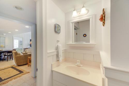 a white bathroom with a sink and a living room at Atlantic Beach Condo - Walk to Beaches! in Atlantic Beach