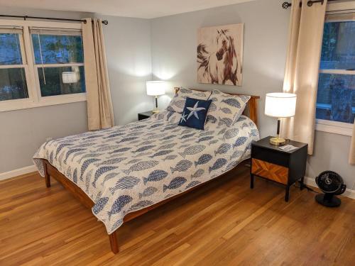 a bedroom with a bed with a blue and white comforter at Spacious 4BR house on a quiet street in Centerville 5 min to Craigville beach in Centerville