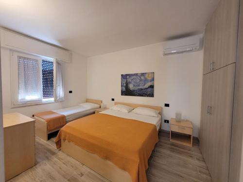 a bedroom with two beds and a window at Alberto Quadrilocale a soli 150m dal mare in Marina di Castagneto Carducci