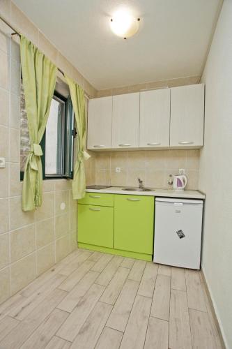 a kitchen with green and white cabinets in a room at Villa Iva in Kotor