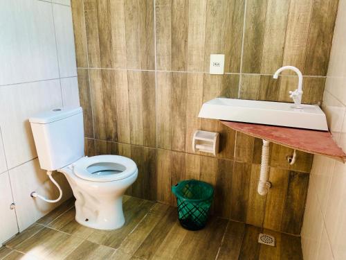 a bathroom with a toilet and a sink at Casa Borboleta na Vila de São Jorge in Alto Paraíso de Goiás