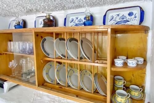 a wooden shelf with plates and cups on it at Poppy's House in Emborios Kalymnos