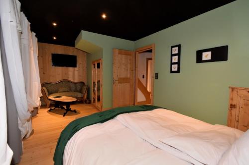 ein Schlafzimmer mit einem Bett, einem Tisch und einem Stuhl in der Unterkunft Chambres d'hôtes La Carrée in Les Fins