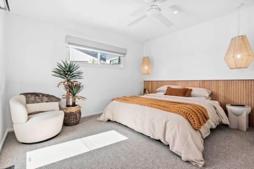 a bedroom with a large bed and a chair at Beautifully presented home that sleeps ten people in Ocean Grove