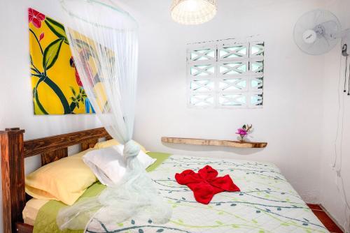 a bedroom with a bed with a red flower on it at Casa Lavanda in tropical jungle garden in Manzanillo