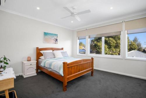 a bedroom with a bed and two windows at Explore Frankston South from this lovely home in Frankston