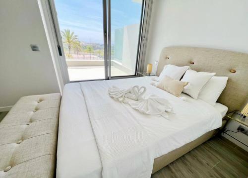 Schlafzimmer mit einem weißen Bett und einem großen Fenster in der Unterkunft Great 3 bedroom Apt in Marbella-Estepona RDR308 in Estepona