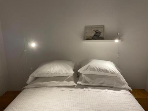a bed with white sheets and pillows in a bedroom at Casa do Porto in Madalena