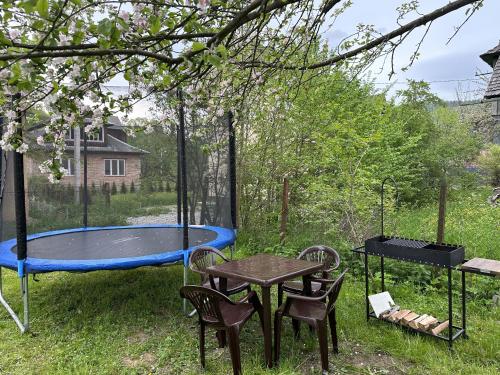 a patio with a trampoline and a table and chairs at Carpathian Dream Apartments in Yaremche
