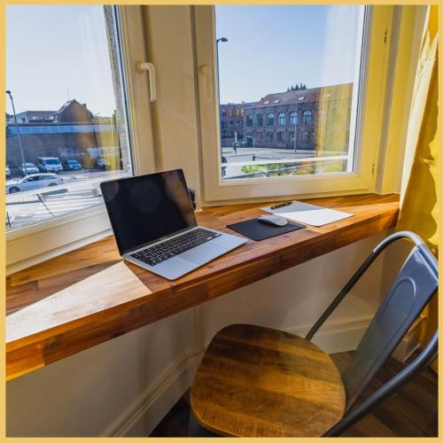 a laptop computer sitting on a desk next to a window at « Le Terminus » à 250m de la gare in Tourcoing