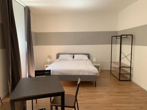a bedroom with a bed and a table and a table and chair at Il Tasso Rooms & Apartments in Trieste