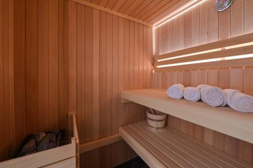 Una sauna con paredes de madera y estantes con toallas blancas. en Villa Luna-Private Heated Pool and sauna, en Novalja