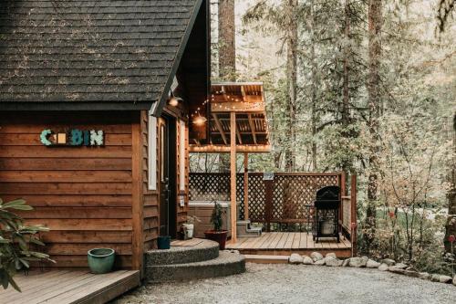 een houten hut met een terras en een veranda bij 16GS Cabin in Glacier