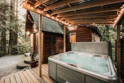a hot tub on a deck next to a cabin at 16GS Cabin in Glacier