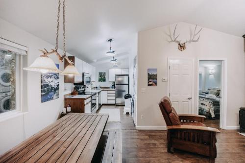 a living room with a wooden table and a kitchen at 16GS Cabin in Glacier