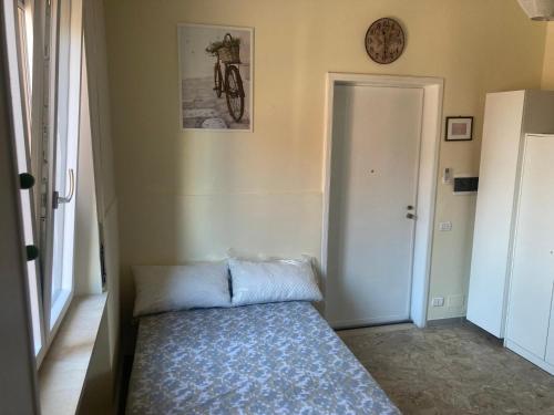 1 dormitorio con 1 cama y reloj en la pared en Residenza Eli en Piacenza