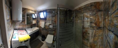 een badkamer met een douche en een wastafel bij Sea Breeze Apartment in Milas