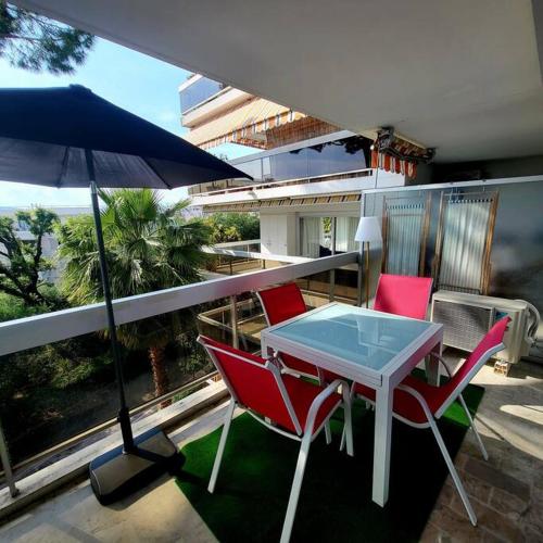 une table et des chaises sur un balcon avec un parasol dans l'établissement Grand studio localisation idéale, à Antibes