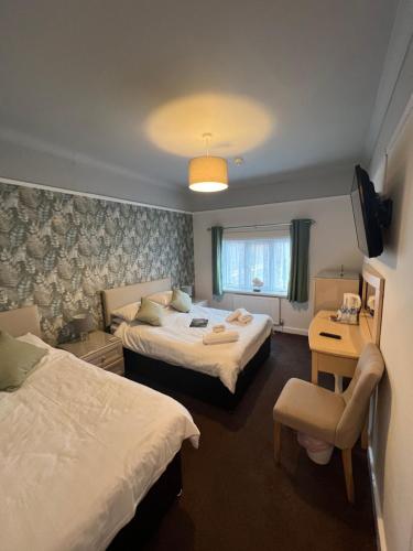 a hotel room with two beds and a television at The Bayridge Guest House in Bridlington